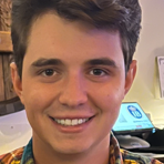 close up portrait of Angelo Valle wearing a yellow, blue, and green patterned shirt